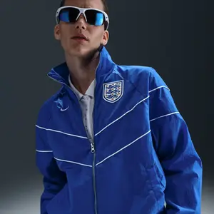 Comparateur de prix : Veste tissée anti-UV Nike Football Angleterre Windrunner pour femme - ...