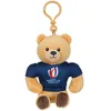 Image de Gipsy Toys - Ours Porte-clés Coupe du Monde de Rugby/Rugby World Cup France 2023 (RWC)   Peluche Officielle sous Licence - 10 cm Assis   Beige Bleu Marine