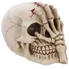Image de DÉCORATION TÊTE DE MORT AVEC MAIN RÉSINE 16CM- DECORS DE TABLE HALLOWEEN